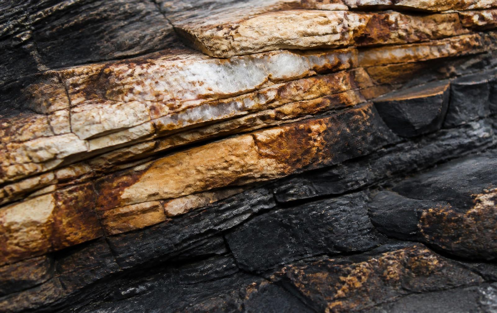 Formação geológica em afloramento rochoso com veios mineralizados